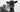 A black + white image of two cows, snuggling each other