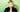 Cathryn Wills stands against a green wall + smiles at the camera