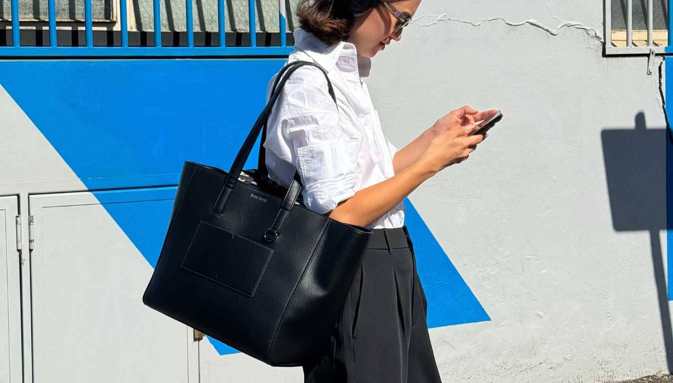 Eugenia carries the Archive Vegan Leather Tote Bag in black