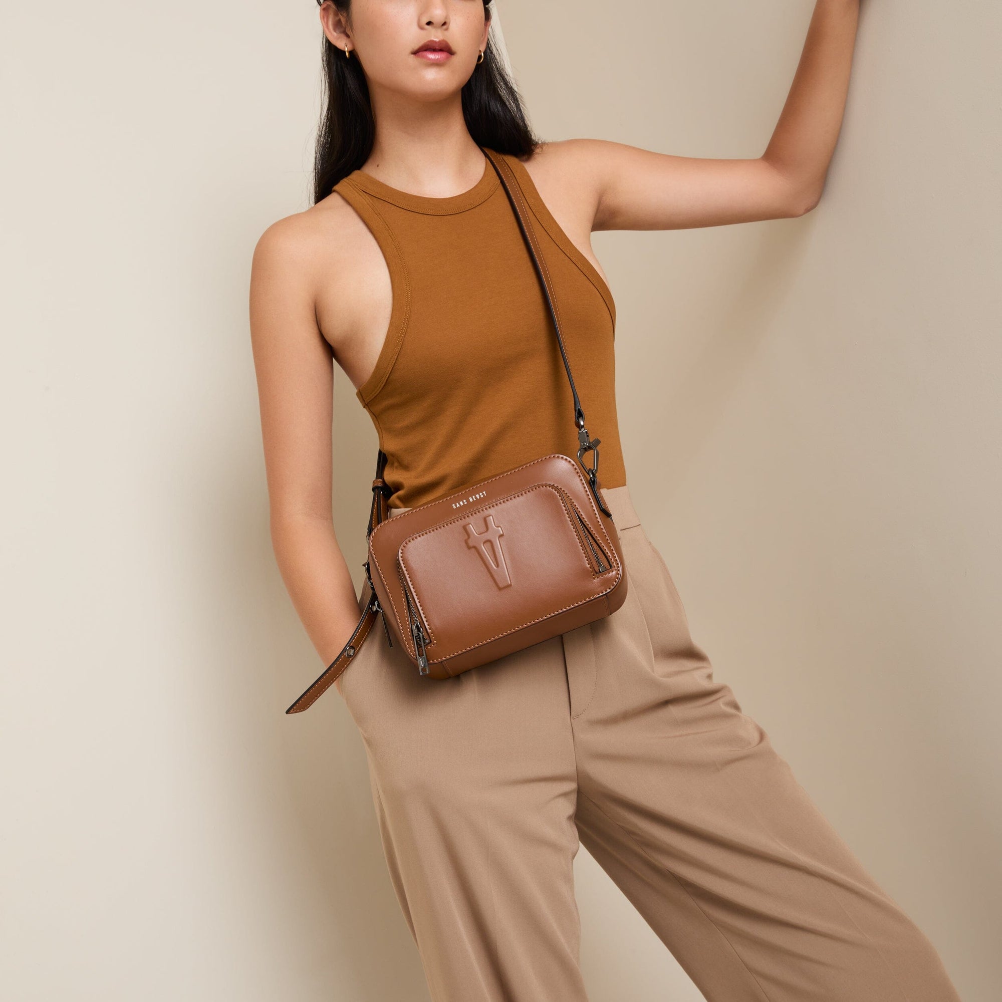 Tari wears a tan toned top + pants with the Sojourn vegan crossbody bag in Cinnamon